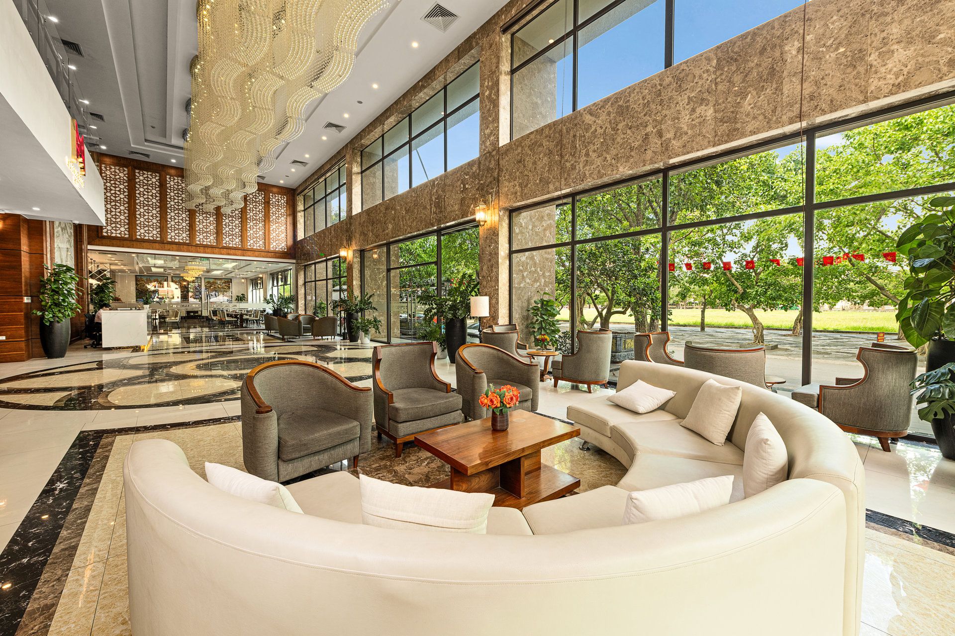 A spacious lobby with a seating area, large windows, and a decorative ceiling.