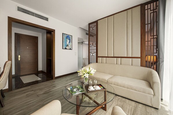 A modern living room with a sofa, a glass coffee table, and a door.