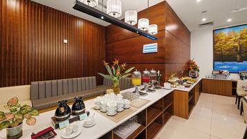 A hotel reception area with a long counter, a seating area, and a painting on the wall.