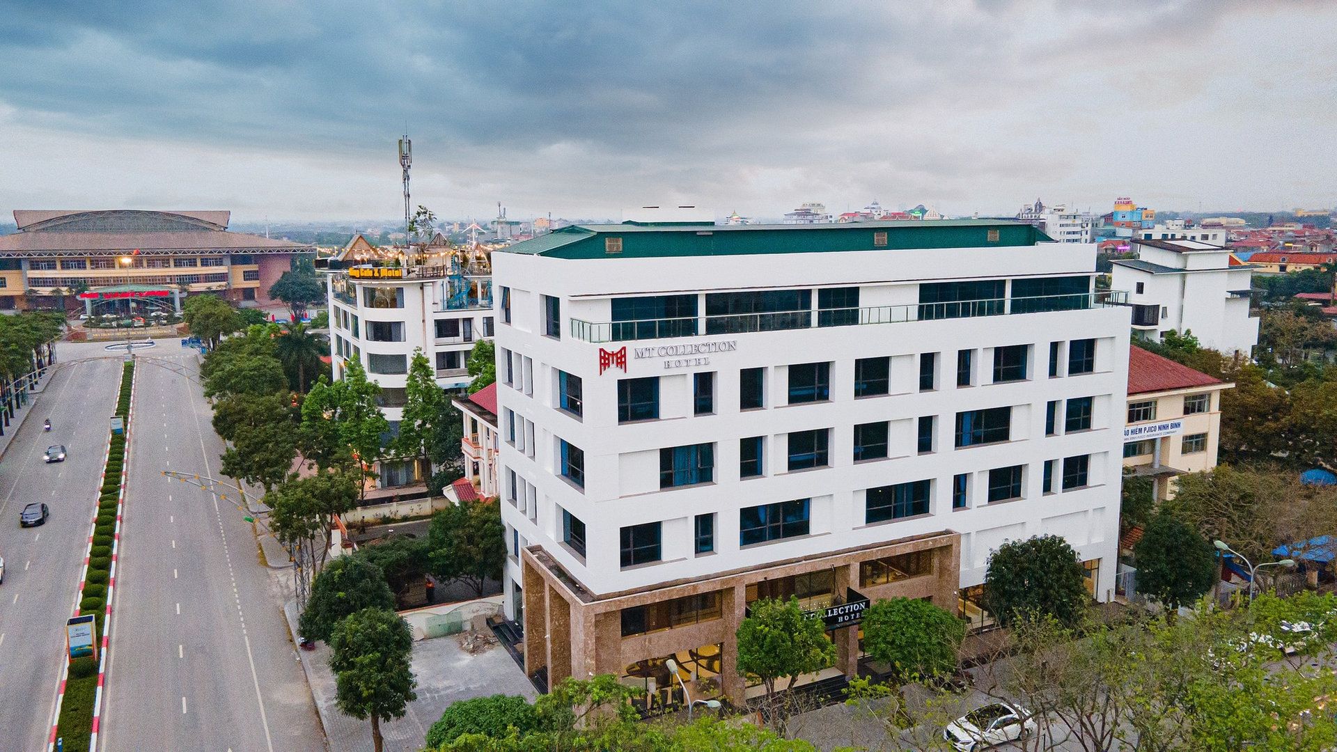 A multi-story hotel with a modern design, featuring a prominent logo on the facade.