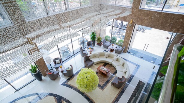 A spacious lobby with a central seating area, large windows, and a decorative ceiling. - MT Collection Hotel (Hoa Lu)