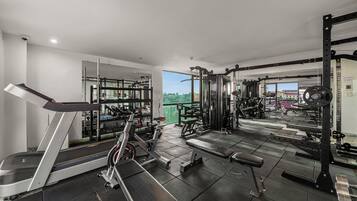 Un gimnasio moderno con cinta de correr, banca para pesas y equipamiento de levantamiento de pesas.