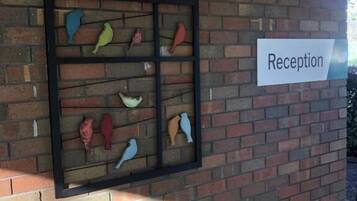 Aula, jossa on tiiliseinä ja kyltti, jossa lukee ”Reseptio”.
