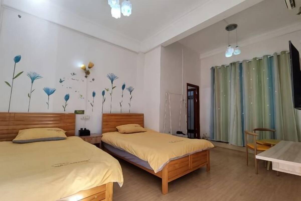 A room with two beds, a table, and a chair.