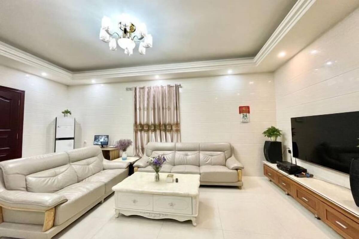 A modern living room with a sectional sofa, a coffee table, a TV, and a cabinet.