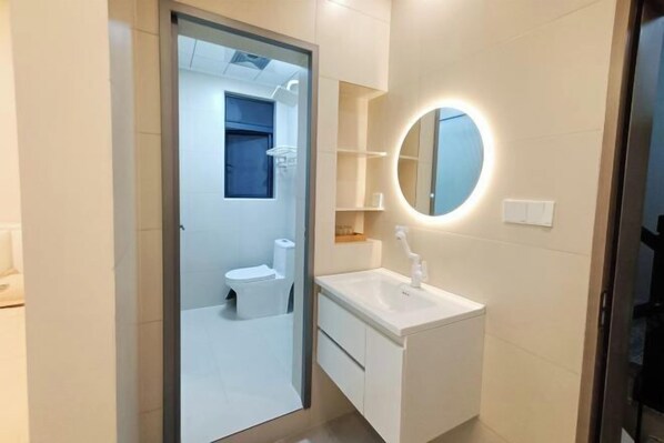 Ein modernes Badezimmer mit Toilette, Waschbecken und Spiegel.