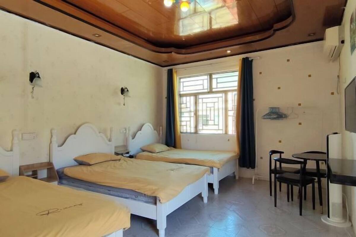 A room with two beds, a small table, and a TV.