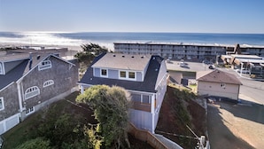 Uma área residencial costeira com casas, uma praia e um grande edifício de hotel.