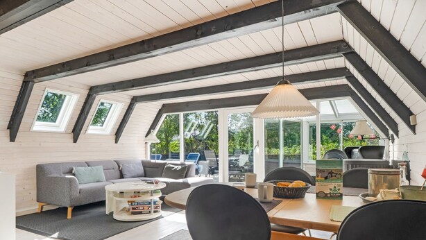 Una habitación estilo loft acogedora, con comedor, sofá y zona de cocina con una parrilla.