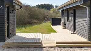 A row of cabins with a wooden deck in front, surrounded by a grassy area and trees. - "Bentine" - 1.6km from the sea by Interhome (Saltum)