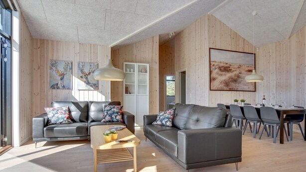 A spacious living area with two leather sofas, a wooden coffee table, and a dining table with chairs. - "Bentine" - 1.6km from the sea by Interhome (Saltum)