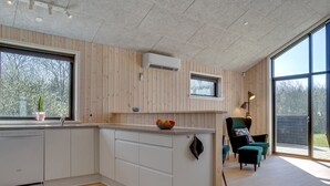 A modern kitchen with wooden paneling, a built-in dishwasher, and a large window. - "Bentine" - 1.6km from the sea by Interhome (Saltum)