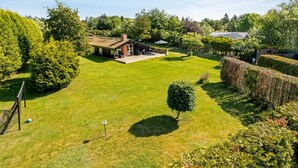 Une pelouse bien entretenue, avec une petite maison et un jardin.