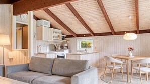 Un intérieur chaleureux avec un canapé, une table à manger et un coin cuisine.