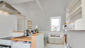 A compact kitchenette with a built-in oven, a small refrigerator, and a wooden countertop. - "Evangelina" - 350m from the sea by Interhome (Løkken)
