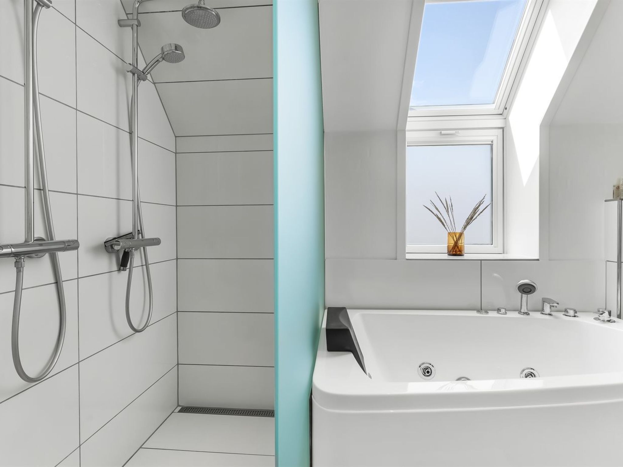 Une salle de bain moderne avec une douche, une baignoire et une fenêtre de toit.