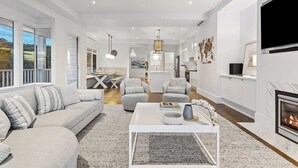 A modern living room with a sofa, coffee table, and fireplace.