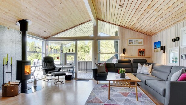 Una sala de estar acogedora con chimenea, un sofá, una mesa de centro y una alfombra.