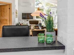 A modern kitchen with a dark countertop, a potted lavender plant, and two mason jars. - "Coco" - 200m from the sea by Interhome (Sæby)