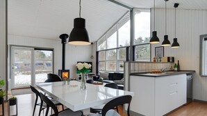 Une cuisine moderne dotée d’un îlot central, de meubles blancs et d’un éclairage suspendu.