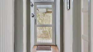 Un couloir avec une porte en verre donnant sur un espace extérieur.