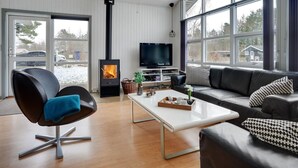 Un salon moderne avec une cheminée, un canapé, une table basse et un téléviseur.