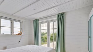 Una camera da letto con un letto, una finestra e vista sul verde.