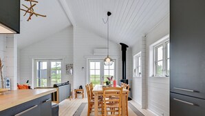Un'ampia cucina con zona pranzo, arredi in legno e ampie finestre.