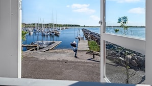 Ein Yachthafen mit vertäuten Booten, eine Anlegestelle, die ins Wasser ragt, und ein klarer Himmel.