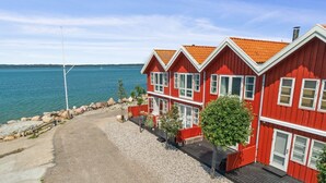 Ein rotes Gebäude mit einer Schotterauffahrt und Blick auf das Wasser.