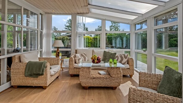 A spacious room with wicker furniture, large windows, and a ceiling with skylights. - "Teija" - 300m from the sea by Interhome (Odder)