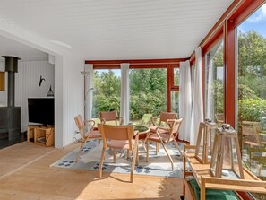 Ein modernes Wohnzimmer mit Kamin, bequemen Sitzmöglichkeiten und großen Fenstern mit Blick ins Freie.