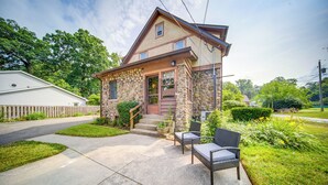 A two-story house with a stone facade, a front porch, and a small garden. - Central Erie Vacation Rental ~ 2 Mi to Beach! (Erie)