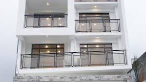 A multi-story building with balconies, large windows, and a flat roof. - morning travel (Lugu)