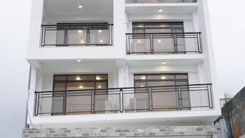 A multi-story building with balconies, large windows, and a flat roof.