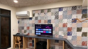 A modern kitchen with a built-in TV, wooden chair, and a patterned backsplash. - morning travel (Lugu)