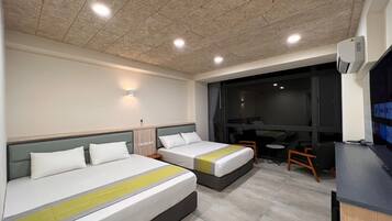 A hotel room with two beds, a desk, and a chair.