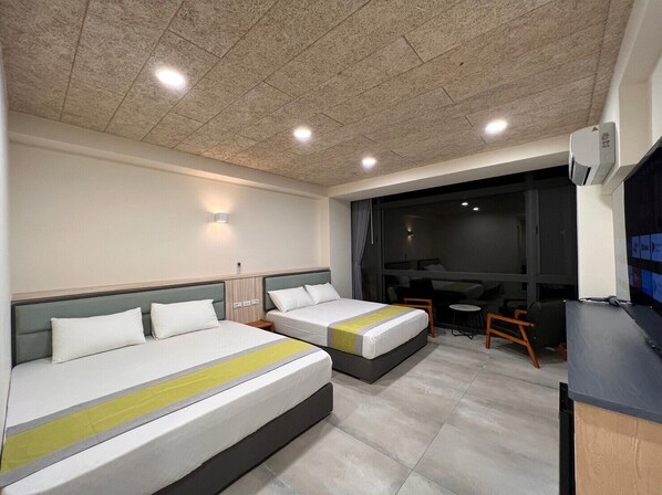 A hotel room with two beds, a desk, and a chair.