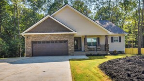 A single-story house with a stone facade, a garage, and a well-maintained lawn. - Charming Pendleton Retreat ~ 5 Mi to Clemson! (Pendleton)