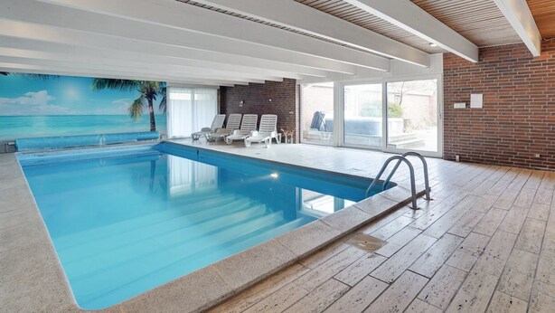 An indoor swimming pool with clear blue water, a wooden ceiling, and a mural of a beach scene. - "Rahild" - 2km to the fjord by Interhome (Thyholm)