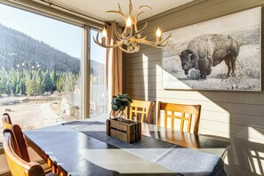 A dining area with a table, chairs, a chandelier, and a large buffalo picture on the wall. - 1 Mi to Keystone Resort: Mtn-View Family Escape! (Keystone)