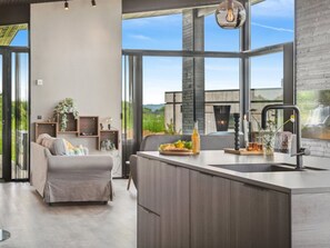 Een moderne keuken met een groot schiereiland, een inbouwspoelbak en uitzicht op een waterval.