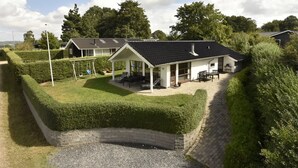 A house with a covered patio, a fenced yard, and a gravel driveway. - "Kyllikki" - 300m to the fjord by Interhome (Børkop)