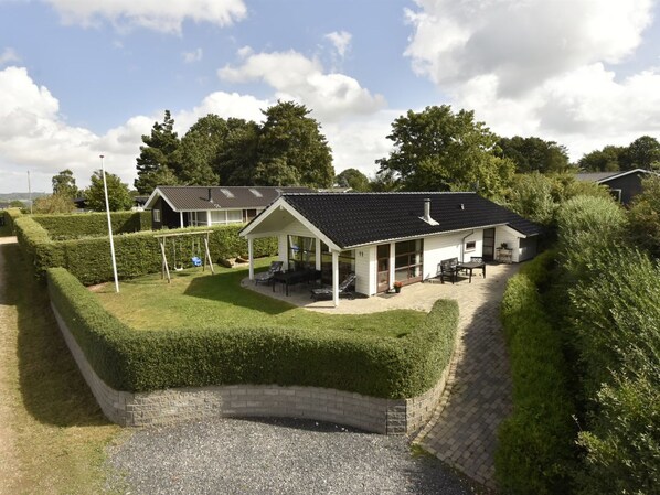 A house with a covered patio, a fenced yard, and a gravel driveway. - "Kyllikki" - 300m to the fjord by Interhome (Børkop)