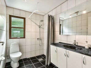 A modern bathroom with a toilet, shower, and sink. - "Kyllikki" - 300m to the fjord by Interhome (Børkop)