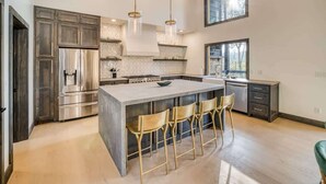 A modern kitchen with a large island, stainless steel appliances, and pendant lighting. - Morgan Trail - Hot tub & ping pong table (Blue Ridge Mountains)