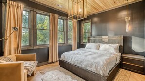 A bedroom with a large bed, a chair, a nightstand, and a lamp. - Morgan Trail - Hot tub & ping pong table (Blue Ridge Mountains)