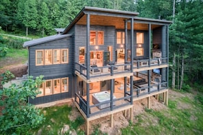 Eine mehrstöckige Holzhütte mit Balkon, Whirlpool und Kamin.