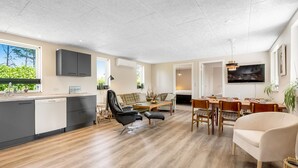 A spacious living area with a kitchen, dining area, and a seating area with a sofa and chairs. - "Eira" - 350m to the fjord by Interhome (Tarm)
