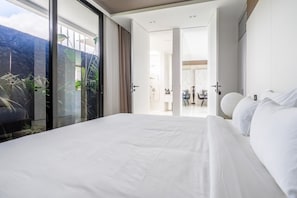 Enjoy a comfortable stay in this stylish room with a large bed and a view of the outdoors through the large window.